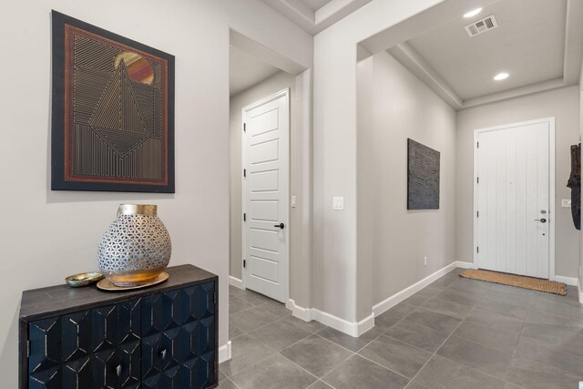 foyer with recessed lighting, visible vents, tile patterned flooring, and baseboards