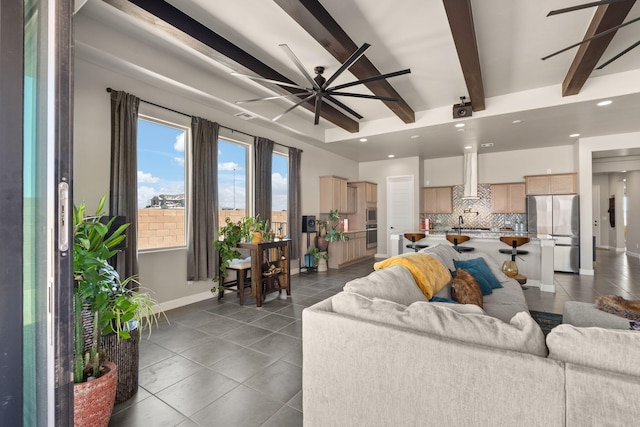 living area with ceiling fan, beamed ceiling, baseboards, dark tile patterned floors, and recessed lighting