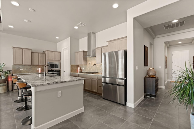 kitchen with wall chimney exhaust hood, tasteful backsplash, stainless steel appliances, and visible vents