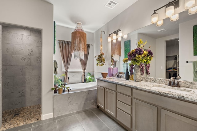 bathroom with a sink, double vanity, visible vents, tile patterned flooring, and a garden tub