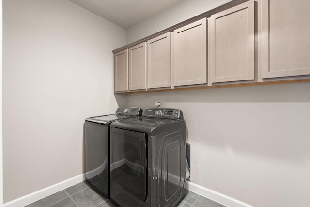 laundry room featuring washing machine and dryer, baseboards, cabinet space, and tile patterned flooring
