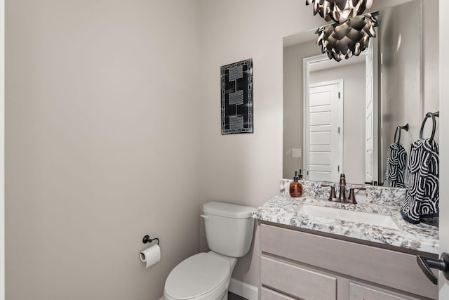 half bath featuring toilet and vanity