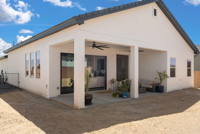rear view of house with stucco siding, a patio area, a ceiling fan, and outdoor lounge area