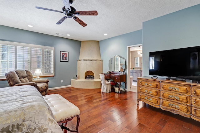living room featuring ceiling fan, a textured ceiling, visible vents, hardwood / wood-style flooring, and recessed lighting