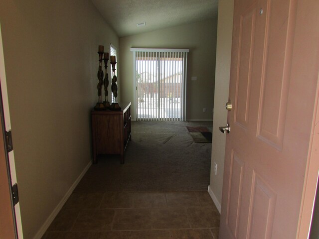 2843 Violeta Cir SE, Rio Rancho, NM 87124 - hall with lofted ceiling, dark colored carpet, dark tile patterned flooring, and baseboards