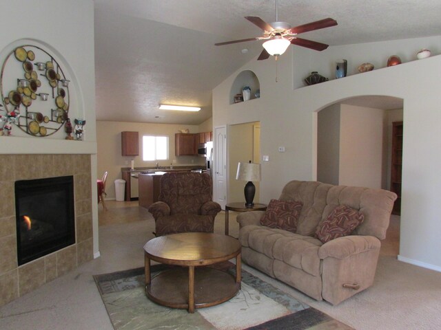 2843 Violeta Cir SE, Rio Rancho, NM 87124 - living area featuring high vaulted ceiling, light carpet, a ceiling fan, and a fireplace