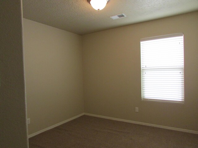 2843 Violeta Cir SE, Rio Rancho, NM 87124 - carpeted spare room with a textured ceiling, visible vents, and baseboards