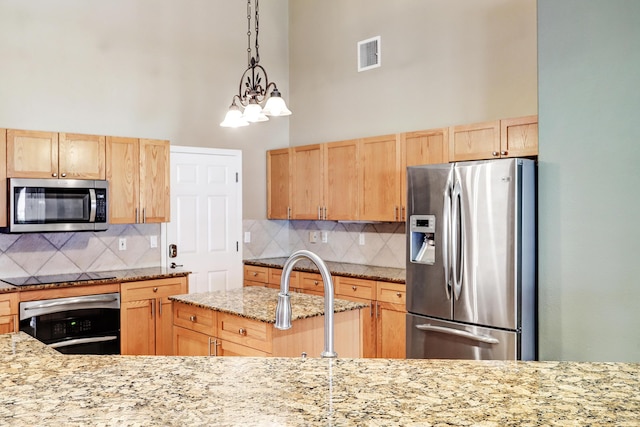 2703 Pueblo Grande Trl NW, Albuquerque, NM 87120 - kitchen featuring light brown cabinets, appliances with stainless steel finishes, tasteful backsplash, and visible vents