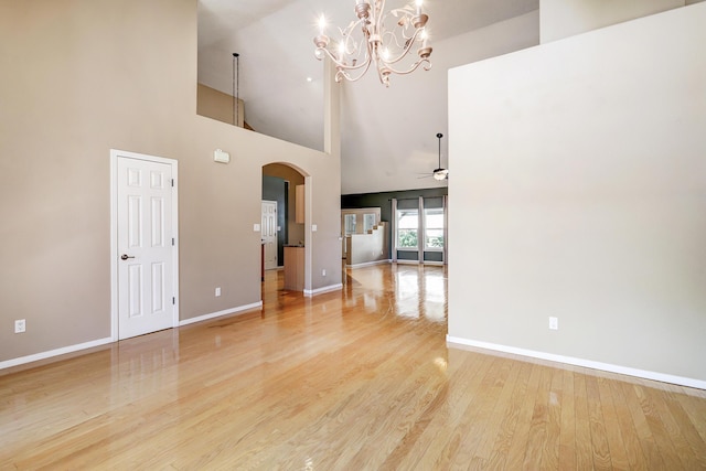 2703 Pueblo Grande Trl NW, Albuquerque, NM 87120 - interior space featuring light wood-style floors, baseboards, arched walkways, ceiling fan with notable chandelier, and a high ceiling
