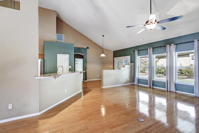 2703 Pueblo Grande Trl NW, Albuquerque, NM 87120 - unfurnished living room with visible vents, ceiling fan, baseboards, light wood-type flooring, and high vaulted ceiling