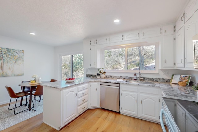4500 Skyline Ct NE, Albuquerque, NM 87111 - kitchen featuring stainless steel dishwasher, a peninsula, light wood-style floors, recessed lighting, and white cabinetry