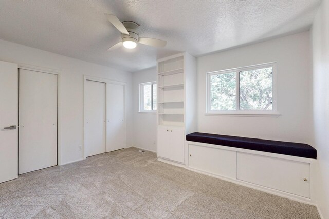 4500 Skyline Ct NE, Albuquerque, NM 87111 - unfurnished bedroom with a textured ceiling, light carpet, multiple closets, and a ceiling fan