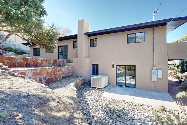 4500 Skyline Ct NE, Albuquerque, NM 87111 - back of property with stucco siding, a patio area, and a chimney