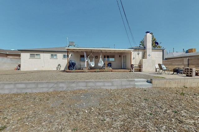 3501 Westerfeld Dr NE, Albuquerque, NM 87111 - back of house featuring a chimney, a fire pit, a patio, and stucco siding