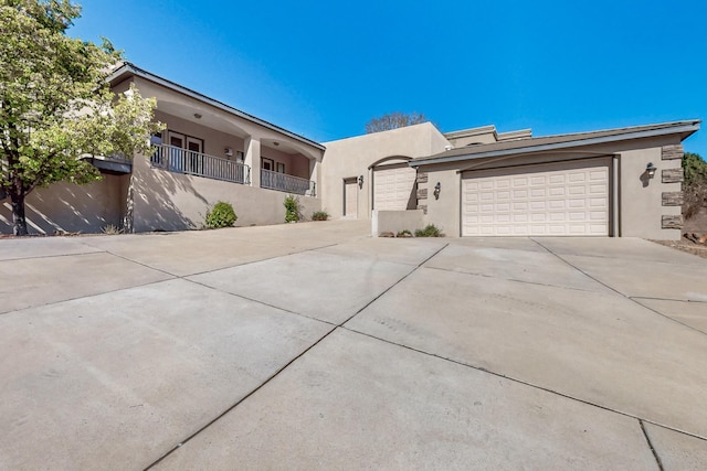 view of front of property featuring an attached garage, driveway, and stucco siding