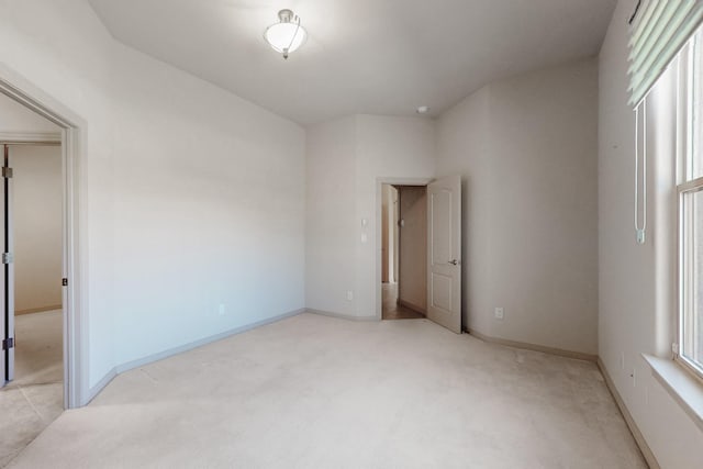 unfurnished bedroom featuring baseboards and light carpet