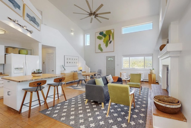 2 Cedar Hill Pl, Cedar Crest, NM 87008 - living area featuring a high ceiling, ceiling fan, light wood-style flooring, a fireplace, and baseboard heating