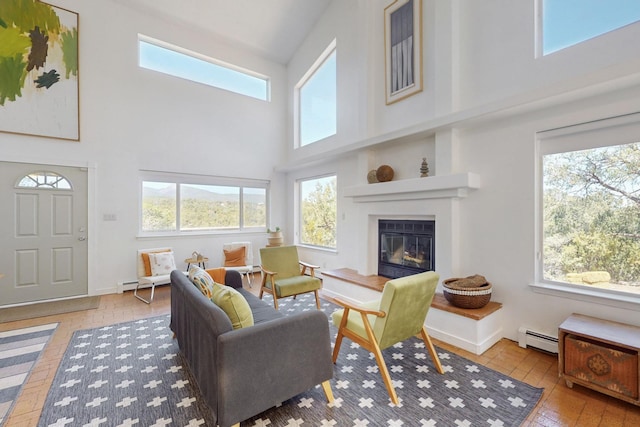 2 Cedar Hill Pl, Cedar Crest, NM 87008 - living area featuring a towering ceiling, a baseboard heating unit, and a glass covered fireplace