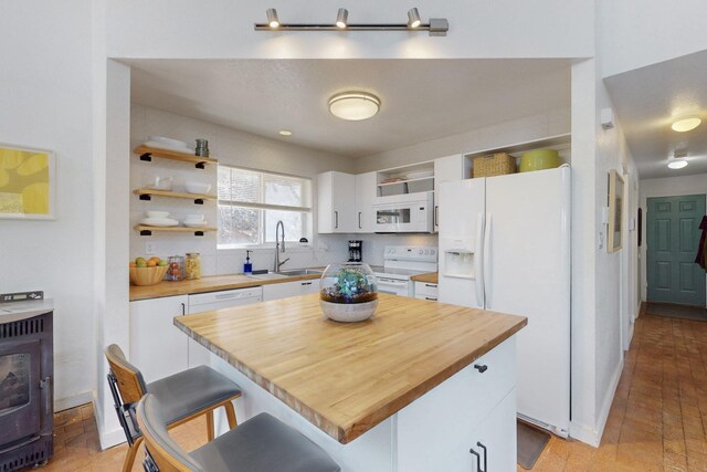 2 Cedar Hill Pl, Cedar Crest, NM 87008 - kitchen with white appliances, open shelves, white cabinets, a kitchen breakfast bar, and a center island