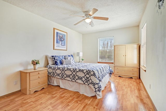 8300 R C Gorman Ave NE, Albuquerque, NM 87122 - bedroom with light wood finished floors, a textured ceiling, and ceiling fan