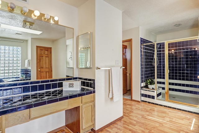 8300 R C Gorman Ave NE, Albuquerque, NM 87122 - full bathroom with a shower stall, vanity, wood finished floors, and a textured ceiling