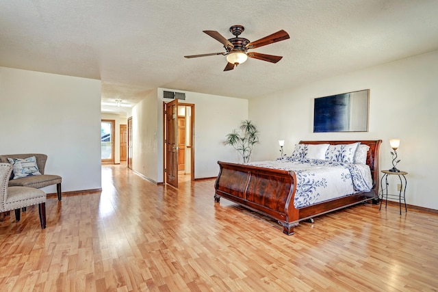8300 R C Gorman Ave NE, Albuquerque, NM 87122 - bedroom with light wood finished floors, a textured ceiling, and ceiling fan