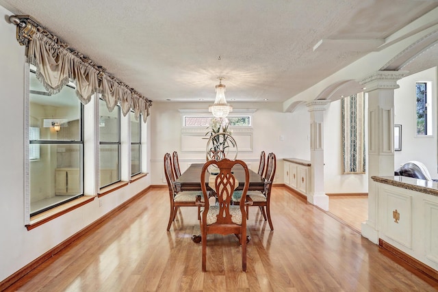 8300 R C Gorman Ave NE, Albuquerque, NM 87122 - dining area featuring light wood-style floors, a textured ceiling, a chandelier, and plenty of natural light