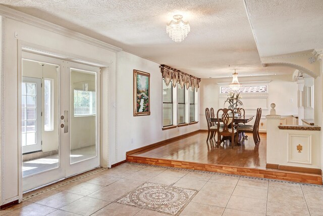 8300 R C Gorman Ave NE, Albuquerque, NM 87122 - dining space with a chandelier, light tile patterned floors, a textured ceiling, and crown molding