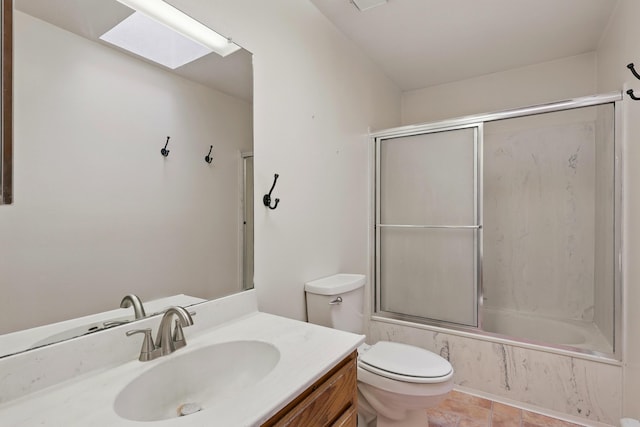 full bath with toilet, a skylight, vanity, and enclosed tub / shower combo