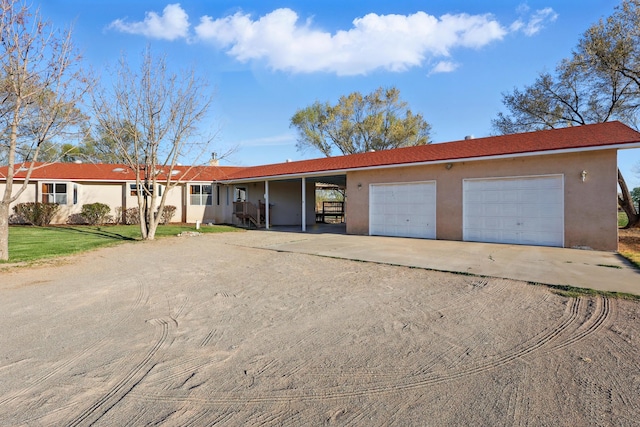 single story home with a garage, driveway, stucco siding, and a front lawn