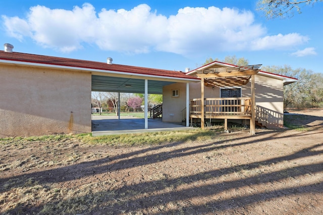 back of house with a carport and a deck