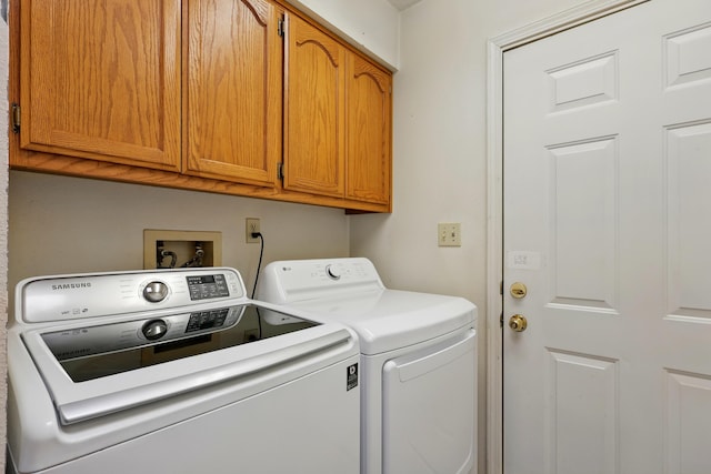 clothes washing area featuring cabinet space and washer and dryer