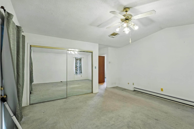 unfurnished bedroom with a closet, vaulted ceiling, carpet floors, visible vents, and a baseboard radiator