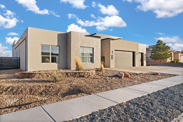8023 Victoria Dr NW, Albuquerque, NM 87120 - view of front facade featuring fence, an attached garage, driveway, and stucco siding