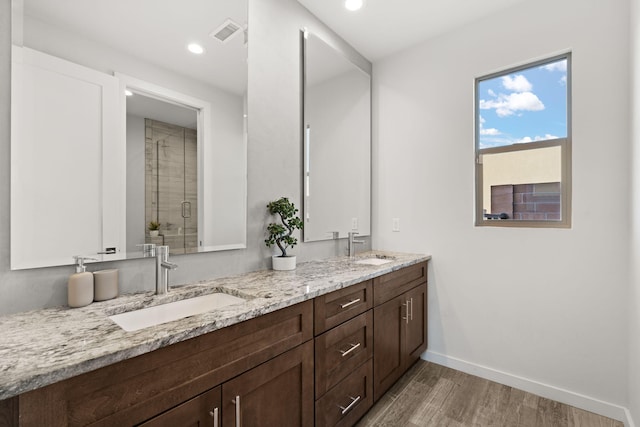 8023 Victoria Dr NW, Albuquerque, NM 87120 - bathroom featuring visible vents, wood finished floors, baseboards, a shower stall, and a sink