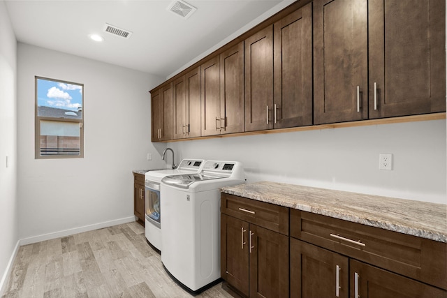 8023 Victoria Dr NW, Albuquerque, NM 87120 - laundry room with visible vents, light wood-type flooring, cabinet space, baseboards, and washer and dryer