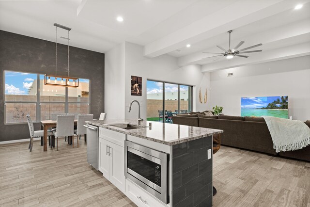 8023 Victoria Dr NW, Albuquerque, NM 87120 - kitchen with light wood-type flooring, recessed lighting, light stone counters, a sink, and appliances with stainless steel finishes