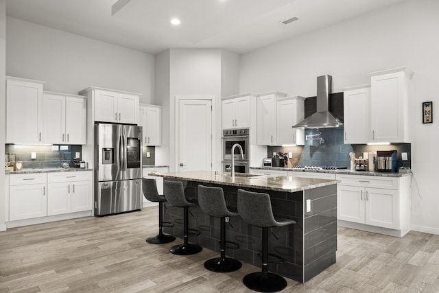 8023 Victoria Dr NW, Albuquerque, NM 87120 - kitchen with white cabinets, a high ceiling, wall chimney exhaust hood, stainless steel appliances, and backsplash