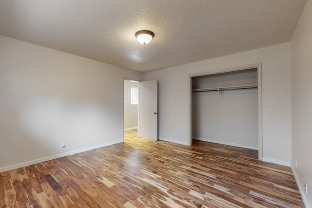 3708 Vermont St NE, Albuquerque, NM 87110 - unfurnished bedroom with a closet, baseboards, wood finished floors, and a textured ceiling