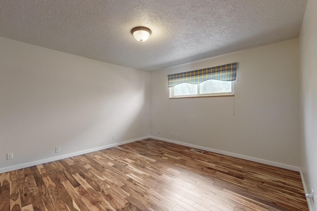 3708 Vermont St NE, Albuquerque, NM 87110 - empty room featuring a textured ceiling, wood finished floors, baseboards, and visible vents