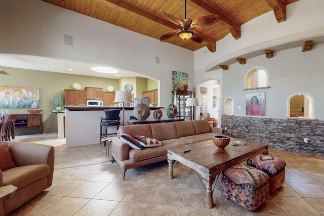 9840 Cameron St NW, Albuquerque, NM 87114 - living room with ceiling fan, arched walkways, beam ceiling, light tile patterned floors, and wooden ceiling