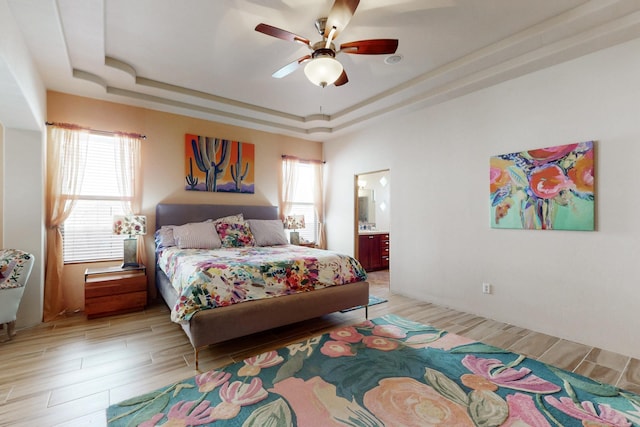 9840 Cameron St NW, Albuquerque, NM 87114 - bedroom with a ceiling fan, a tray ceiling, light wood-style flooring, and ensuite bath