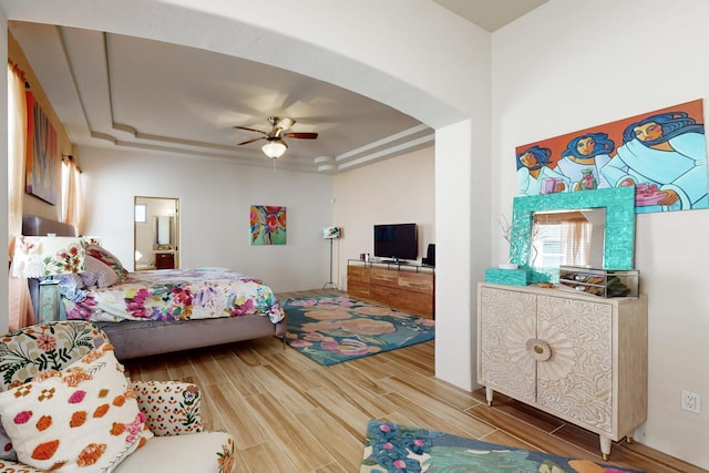 9840 Cameron St NW, Albuquerque, NM 87114 - bedroom featuring wood tiled floor, a ceiling fan, arched walkways, a raised ceiling, and ensuite bathroom