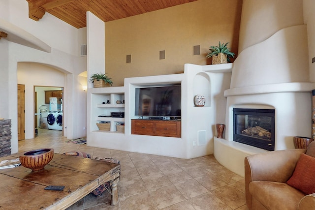 9840 Cameron St NW, Albuquerque, NM 87114 - tiled living room featuring visible vents, a fireplace, high vaulted ceiling, wooden ceiling, and independent washer and dryer