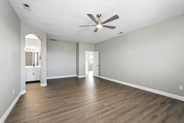 7327 Hearthstone Rd NW, Albuquerque, NM 87114 - unfurnished room featuring a ceiling fan, arched walkways, a textured ceiling, wood finished floors, and baseboards