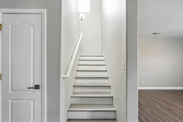 7327 Hearthstone Rd NW, Albuquerque, NM 87114 - staircase featuring wood finished floors, baseboards, and a textured ceiling