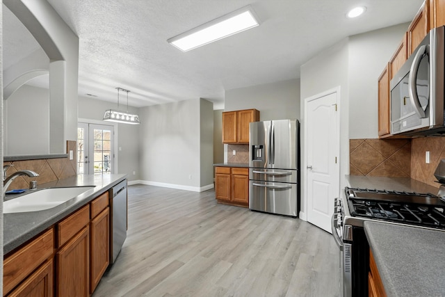 7327 Hearthstone Rd NW, Albuquerque, NM 87114 - kitchen with appliances with stainless steel finishes, a sink, backsplash, brown cabinetry, and recessed lighting