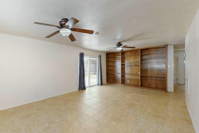 spare room featuring baseboards, ceiling fan, built in shelves, and light tile patterned floors