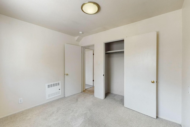 unfurnished bedroom featuring visible vents, light carpet, and a closet