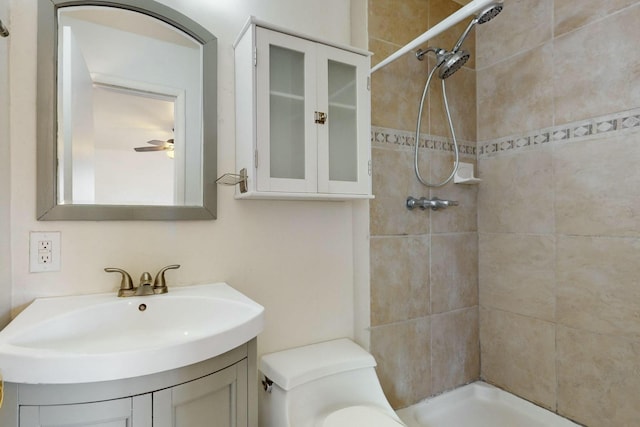 bathroom featuring vanity, a ceiling fan, toilet, and tiled shower